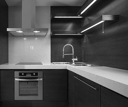 Black kitchen cabinets, white countertops and stainless steel appliances