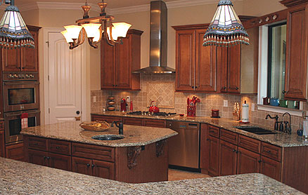 Traditional Italian kitchen design - wood cabinets in combination with stone counters, stone backsplashes and stainless steel appliances. There is also a large chandelier over the island