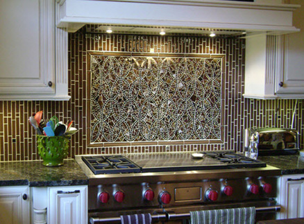 Mosaic backsplash, stainless steel appliances, and white cabinets