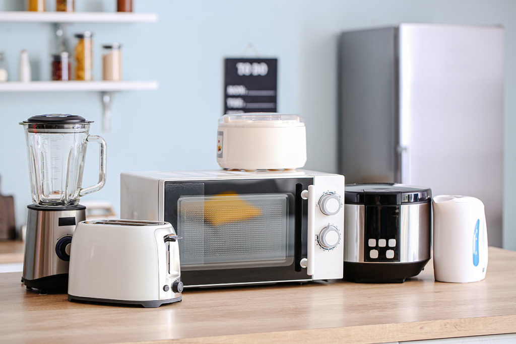 Different household appliances on table in kitchen